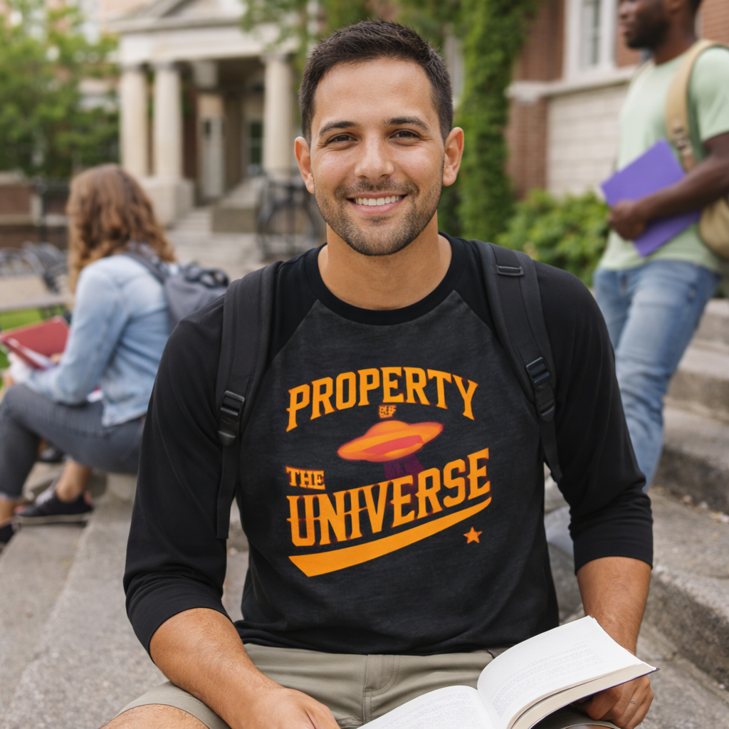 Man wearing a black t-shirt with 'Property of the Universe' text, sitting outdoors on steps.