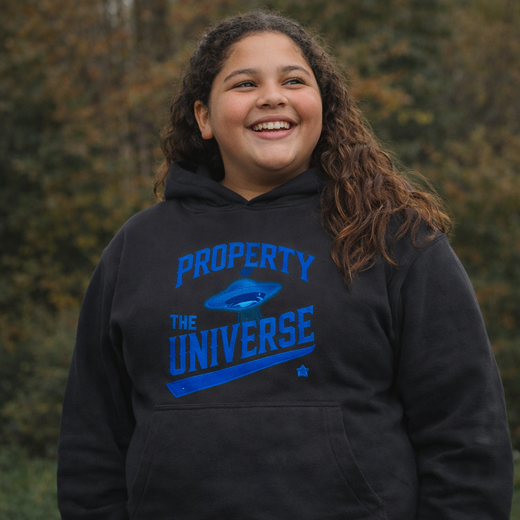 Person wearing a black hoodie with blue text 'PROPERTY OF THE UNIVERSE' against a blurred natural background.